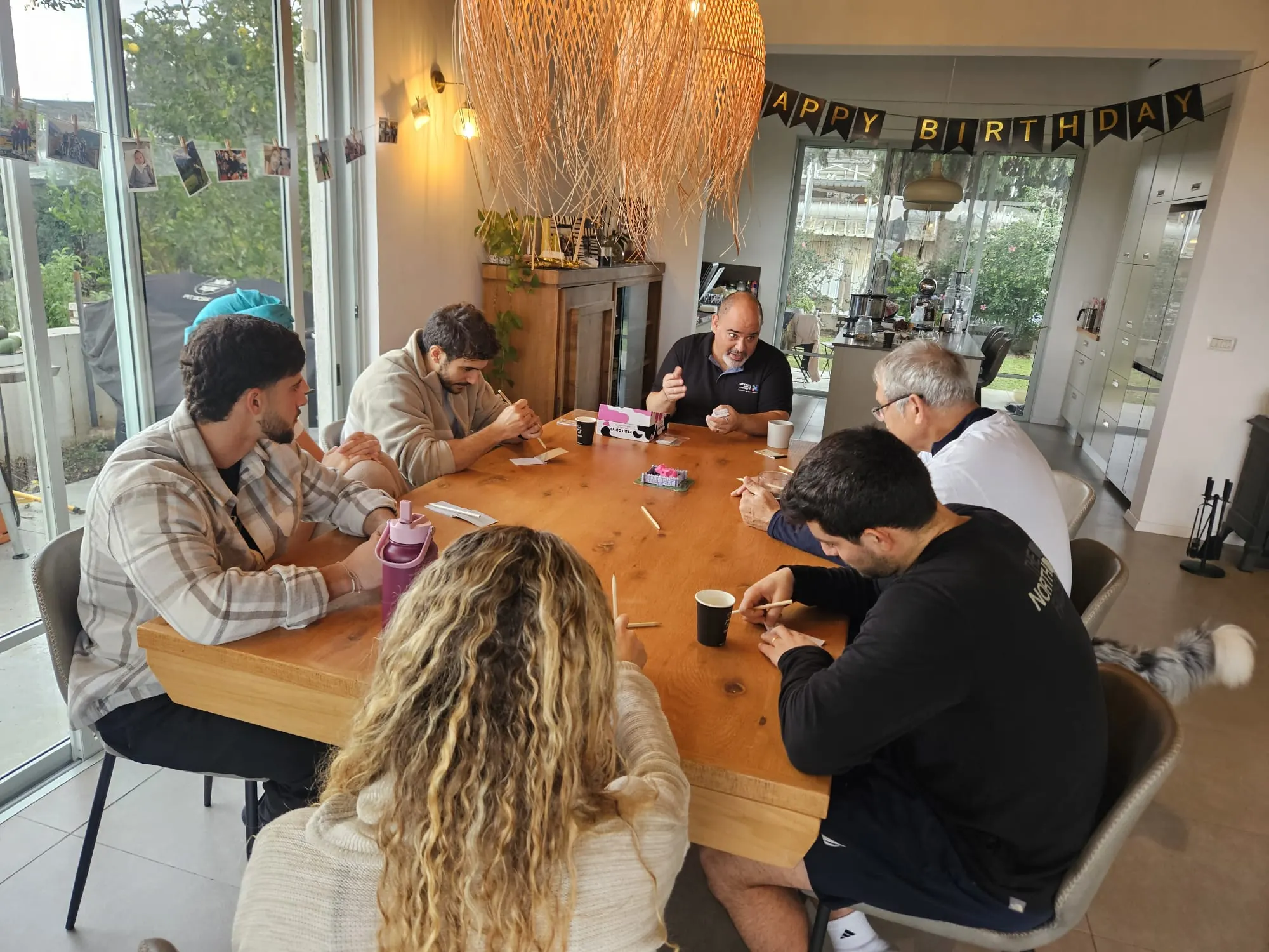 משפחה וחברים משחקים יחד סביב שולחן באירוע פרטי